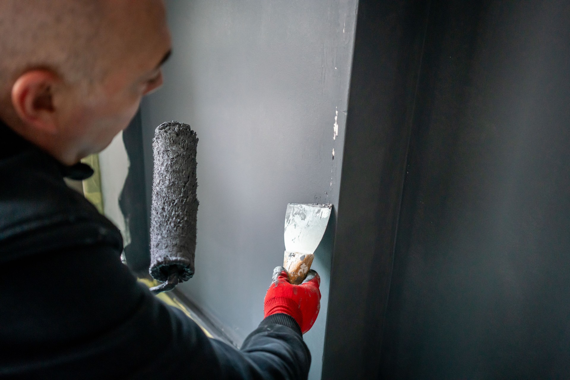 painting roller and spatula are in male painter hand horizontal fixer upper home still